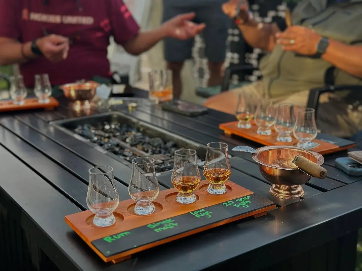 A flight of Valor Peak whiskeys on a wooden tasting board